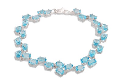Lot 81 - A DIAMOND AND BLUE TOPAZ BRACELET, mounted in...