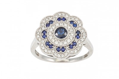 Lot 177 - A DIAMOND AND SAPPHIRE CLUSTER RING, shaped...
