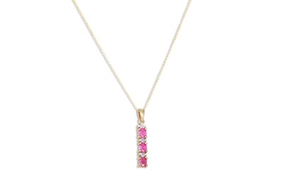 Lot 59 - A THREE STONE RUBY DROP PENDANT, mounted in...