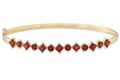 Lot 139 - A GARNET AND GOLD HINGED BANGLE, the round and...