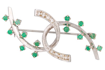 Lot 62 - A DIAMOND AND EMERALD BROOCH, intertwined...