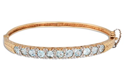 Lot 83 - A DIAMOND AND TOPAZ SET BANGLE, carved...