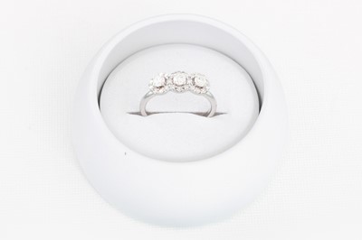 Lot 73 - A DIAMOND TRIPLE CLUSTER RING, of halo design,...