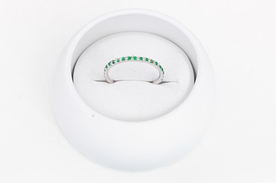 Lot 79 - A DIAMOND AND EMERALD THREE QUARTER ETERNITY...