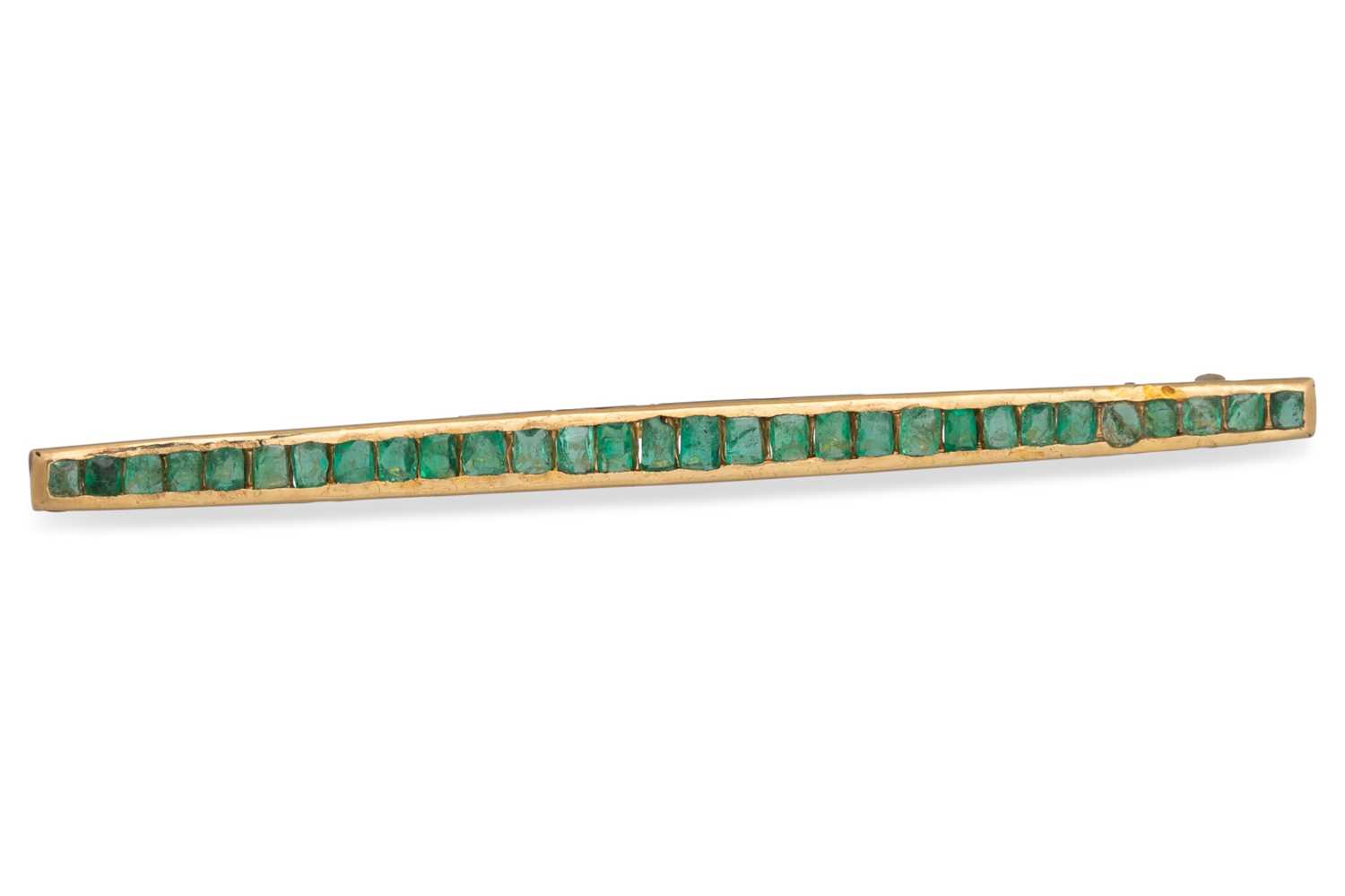 Lot 8 - AN EMERALD SET BAR BROOCH, the graduated trap...
