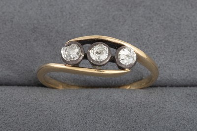 Lot 68 - A VINTAGE THREE STONE DIAMOND TWIST RING, in...