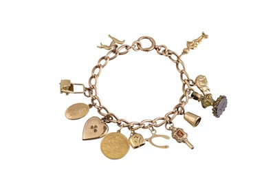 Lot 189 - A VINTAGE GOLD CURB LINK CHARM BRACELET, ten...