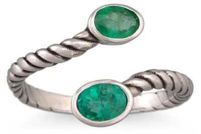 Lot 223 - AN EMERALD CROSS OVER RING, mounted in...
