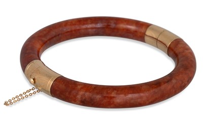 Lot 20 - A JADE HINGED BANGLE, the brownish-orange...