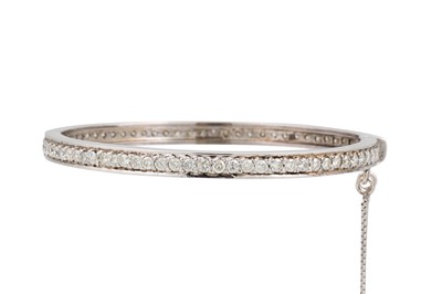 Lot 234 - A DIAMOND SET BANGLE, the brilliant cut...