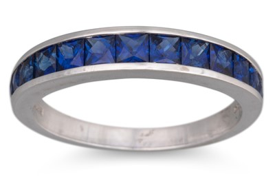 Lot 91 - A SAPPHIRE SET BAND RING, the calibré cut...