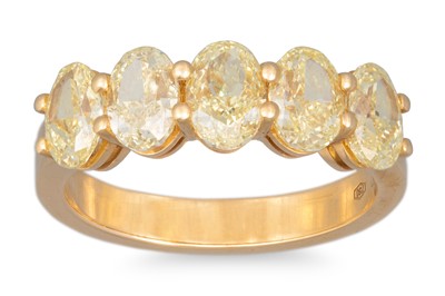 Lot 250 - AN OVAL YELLOW DIAMOND FIVE STONE RING,...