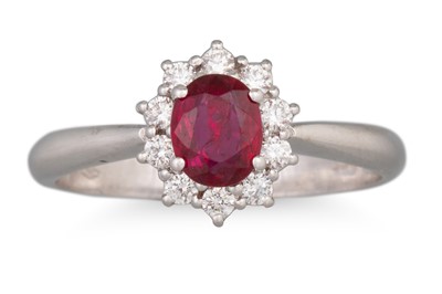 Lot 101 - A RUBY AND DIAMOND CLUSTER RING, the oval ruby...