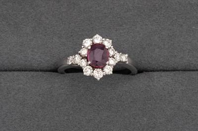 Lot 51 - A DIAMOND AND RUBY CLUSTER RING, oval ruby to...