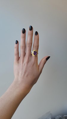 Lot 77 - AN AMETHYST RING, carved decoration to gold...