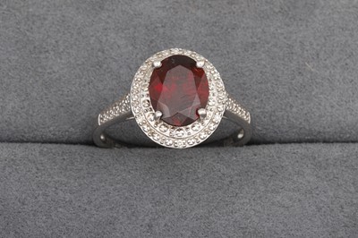 Lot 93 - A GARNET AND DIAMOND CLUSTER RING, mounted in...