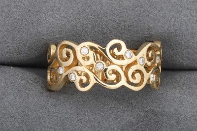 Lot 99 - A DIAMOND SET BAND RING, of scrolled design,...