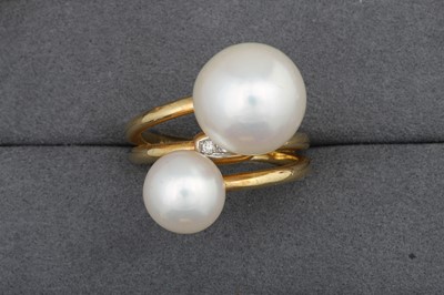 Lot 111 - A PEARL AND DIAMOND CROSS - OVER RING, mounted...
