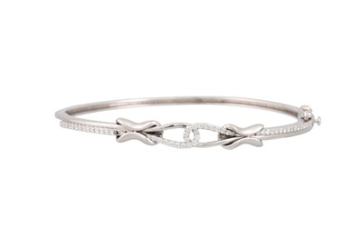 Lot 119 - A DIAMOND SET BANGLE, of knot form design,...