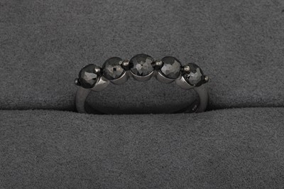 A BLACK DIAMOND FIVE STONE RING, mounted in...
