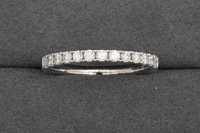 Lot 90 - A DIAMOND HALF ETERNITY RING, mounted in...