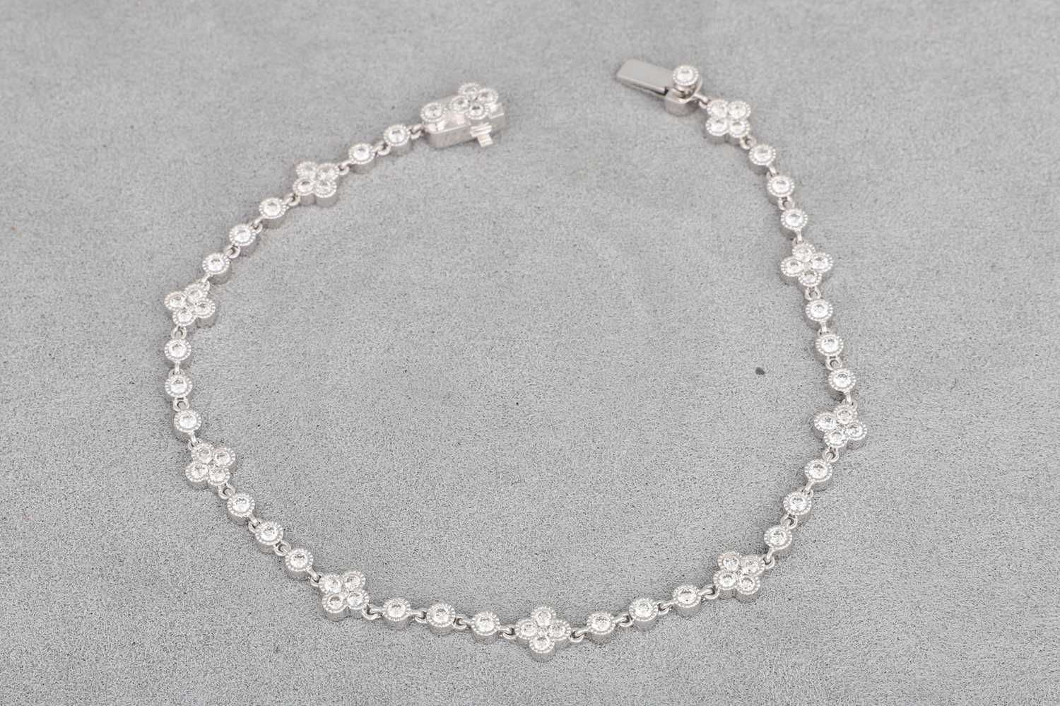 Lot 94 - A DIAMOND SET BRACELET, with collet set...