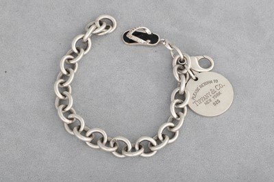 Lot 163 - A TIFFANY & CO. CURB LINK BRACELET, suspending...