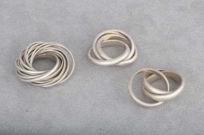 Lot 166 - THREE SILVER RINGS, two with interlocking...