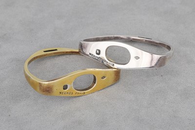 Lot 151 - A PAIR OF HERMÉS SILVER NAPKIN RINGS, one gold...