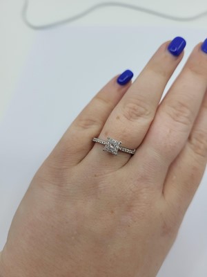 Lot 273 - A DIAMOND CLUSTER RING, set with a princess...