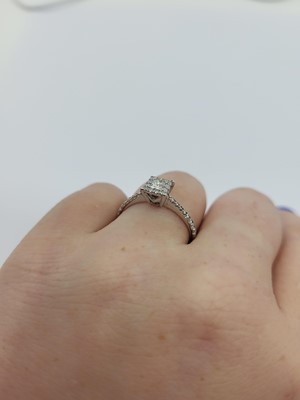 Lot 273 - A DIAMOND CLUSTER RING, set with a princess...