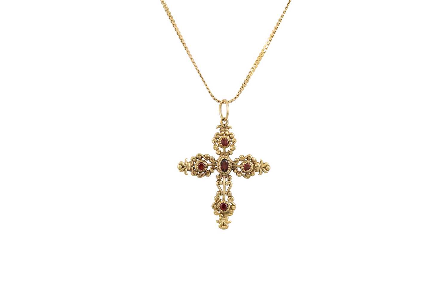 Lot 24 - A GARNET SET CROSS, mounted in gold, shaped...