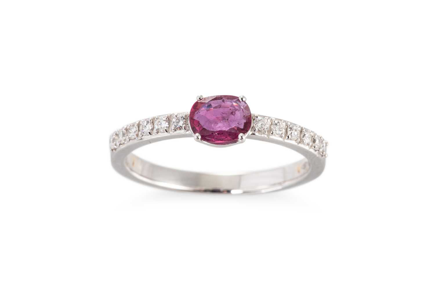 Lot 62 - A RUBY AND DIAMOND SET BAND RING, the oval...