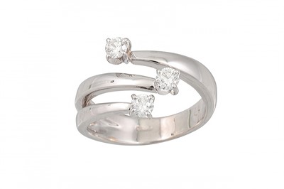 Lot 167 - A DIAMOND CROSS-OVER RING, set with three...
