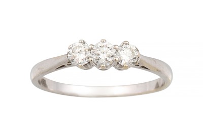 Lot 214 - A THREE STONE DIAMOND RING, the brilliant cut...