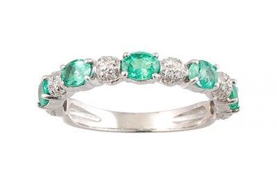 Lot 376 - AN EMERALD AND DIAMOND HALF ETERNITY RING, set...