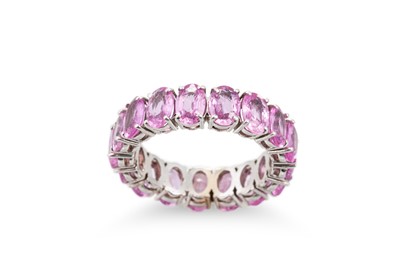 Lot 412 - A PINK SAPPHIRE FULL ETERNITY RING, the oval...