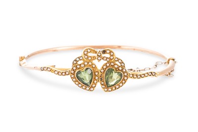 Lot 345 - AN EDWARDIAN PERIDOT AND SEED PEARL BANGLE,...