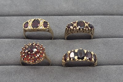 Lot 6 - FOUR GARNET SET CLUSTER RINGS, all mounted in...