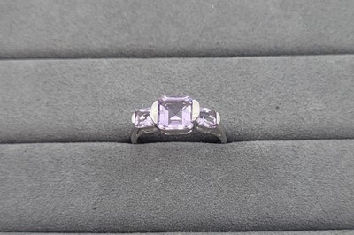 Lot 12 - A THREE STONE AMETHYST RING, the rectangular...