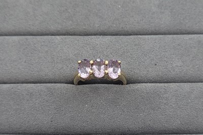 Lot 13 - A THREE STONE AMETHYST RING, the oval...