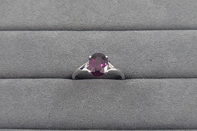 Lot 14 - A GARNET AND DIAMOND SET RING, the oval garnet...