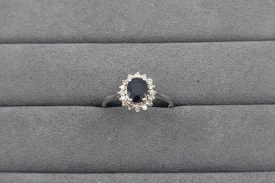 Lot 35 - A SAPPHIRE AND DIAMOND CLUSTER RING, the oval...