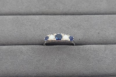 Lot 47 - A SAPPHIRE AND OPAL SET FIVE STONE RING, the...
