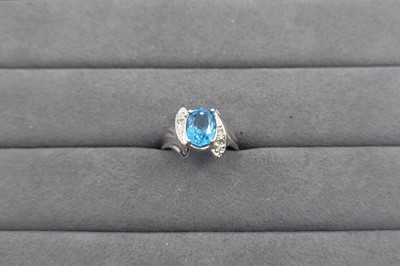 Lot 50 - A TOPAZ AND DIAMOND SET CLUSTER RING, the oval...