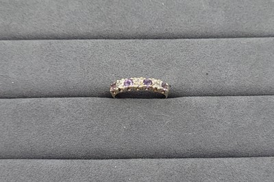 Lot 51 - AN AMETHYST AND DIAMOND SET BAND RING, the...