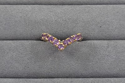 Lot 54 - AN AMETHYST SET WISHBONE RING, the round cut...