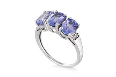 Lot 56 - A TANZANITE THREE STONE RING, the oval...
