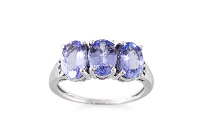 Lot 51 - A TANZANITE THREE STONE RING, the oval...