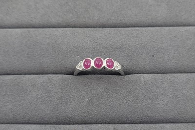 Lot 57 - A RUBY AND DIAMOND SET BAND RING, the bezel...